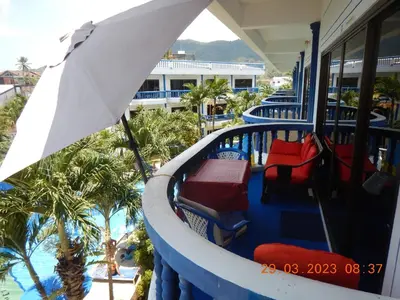 a balcony of a resort with chairs and a pool at Homely with pool near the beach in Kamala Phuket in Kamala Beach