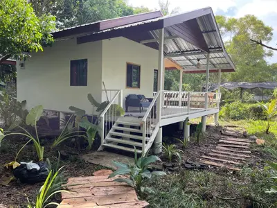 a house with a porch and stairs leading to it at Big hug home-Forest House in Ban Takhrai
