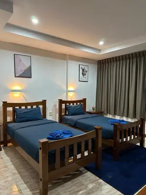 two beds in a bedroom with blue sheets at BT hotel Kata Beach in Kata Beach