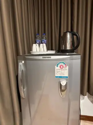 a small refrigerator with a tea kettle on top of it at BT hotel Kata Beach in Kata Beach