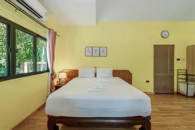 a bedroom with a large white bed in a room at Coco Retreat Phuket Resort and Spa - SHA Plus in Chalong