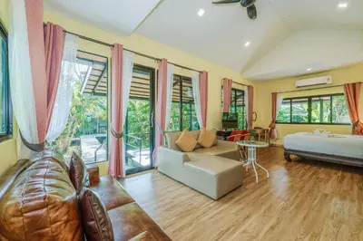 a living room with a couch and a table at Coco Retreat Phuket Resort and Spa - SHA Plus in Chalong