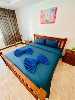 a bed with blue sheets with blue bows on it at BT hotel Kata Beach in Kata Beach