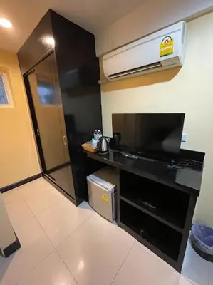 a small kitchen with a black counter and a television at The Elegant Patong in Patong Beach