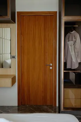 a wooden door in a room with a shirt at Elite Atoll Serviced Apartments Phuket in Rawai Beach