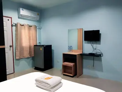 a blue room with a bed and a tv and a desk at Heimat Garden Homestay in Ban Lo Pa Ret