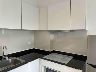 a white kitchen with a sink and white cabinets at Luxury condo in phuket shopping center in Phuket Town