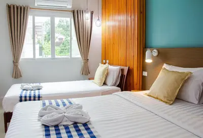two beds in a hotel room with towels on them at Kamala Beach Residence in Kamala Beach
