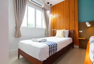 a bedroom with a bed with white sheets and a window at Kamala Beach Residence in Kamala Beach
