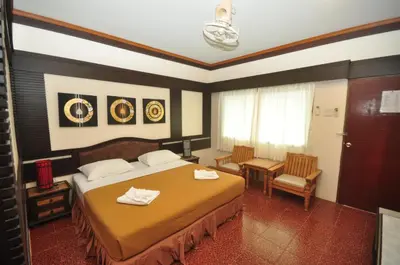 a hotel room with a bed and a table and chairs at Phi Phi Rimlay Resort in Phi Phi Don