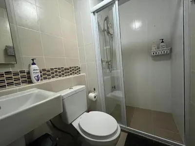 a bathroom with a shower and a toilet and a sink at Cozy and delightful room with pool view in Kathu
