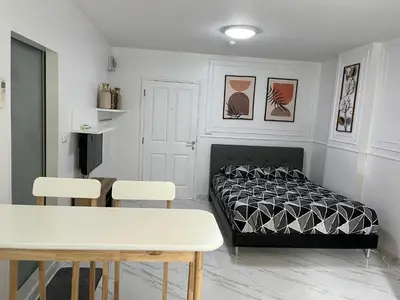 a bedroom with a bed and a table and chairs at Cozy and delightful room with pool view in Kathu