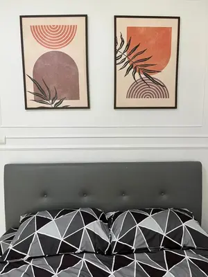 a bedroom with two framed pictures above a bed at Cozy and delightful room with pool view in Kathu