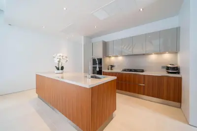 a kitchen with wooden cabinets and a counter top at Spacious Mansion 4BR Villa Anchan V20 with 15m Private Pool in Gated Residence in Bang Tao Beach