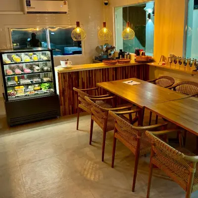 a restaurant with a refrigerator and tables and chairs at L’Oasis Nanai in Patong Beach