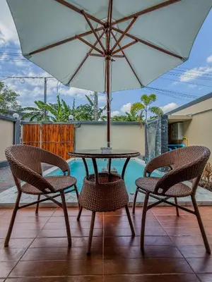 a table and two chairs with an umbrella on a patio at Luxury Boutique Pool Villa Ao Nang Krabi in Ao Nam Mao