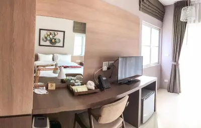 a room with a desk with a computer and a bed at Bangnu Greenery Resort in Takua Thung