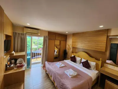a hotel room with a large bed with a television at Alaita Hostel Patong in Patong Beach