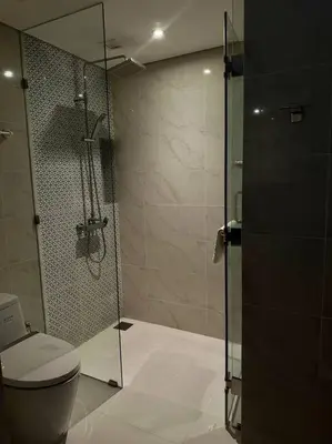 a bathroom with a toilet and a glass shower at Квартира Cassia Residences Lake View in Bang Tao Beach