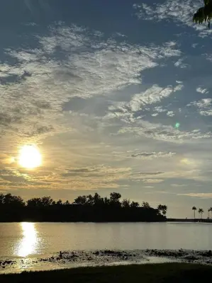 a sunset over a body of water with the sun in the sky at Квартира Cassia Residences Lake View in Bang Tao Beach