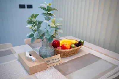 a basket of fruit on a table with a vase at Room61-รูม61 in Phuket Town