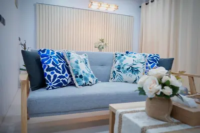 a blue couch with blue and white pillows in a living room at Room61-รูม61 in Phuket Town