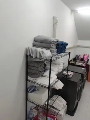 a room with a shelf with towels and a printer at The Residence Resort in Phuket Town
