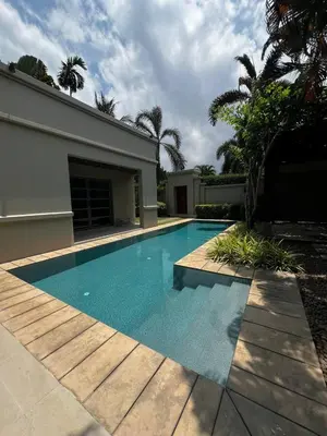 a swimming pool in front of a house at The Residence Resort in Phuket Town