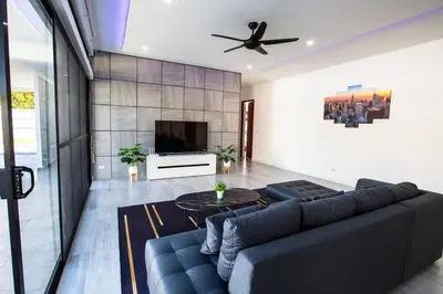 a living room with a blue couch and a tv at Sweet Luxury by G Estate Phuket in Ban Saiyuan (1)