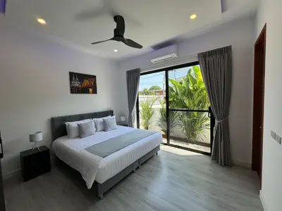 a bedroom with a bed and a large window at Sweet Luxury by G Estate Phuket in Ban Saiyuan (1)