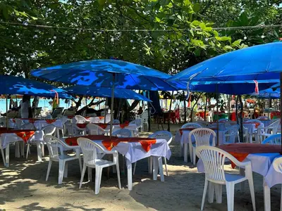 a group of tables and chairs with blue umbrellas at Great Hill Tropic View Pool Gym Naiyang in Nai Yang Beach