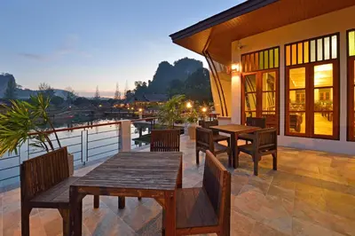 a patio with wooden tables and chairs on a balcony at Poonsiri Resort Aonang-SHA Extra Plus in Ao Nang Beach