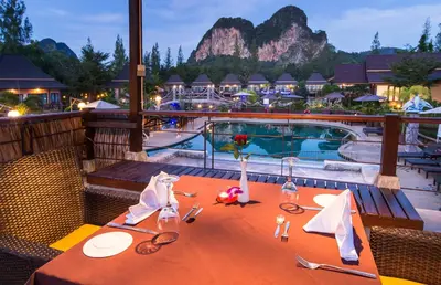 a table with glasses and napkins on it next to a pool at Poonsiri Resort Aonang-SHA Extra Plus in Ao Nang Beach