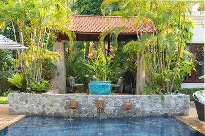 a swimming pool with a fountain in a resort at Saitaan Villa Dennapa Bang Tao Beach in Bang Tao Beach