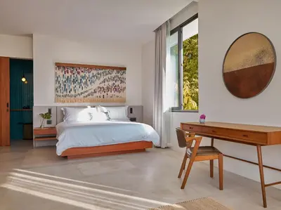a bedroom with a bed and a desk and a mirror at Casa Alma by Elite Havens in Nai Harn Beach