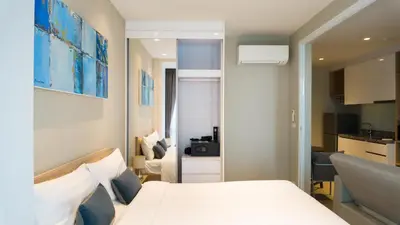 a bedroom with a white bed and a kitchen at Diamond Apartment with Terrace near Bang Tao Beach in Bang Tao Beach