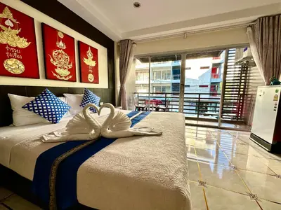 a bedroom with a large bed with a large window at Thai Classic House in Patong Beach