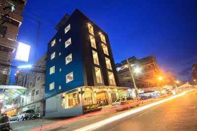 a tall building on a city street at night at Hotel The Journey Patong New in Patong Beach