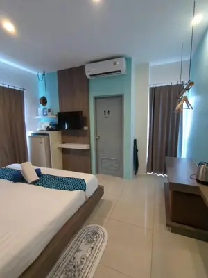 a bedroom with a large bed and a kitchen at Hotel The Journey Patong New in Patong Beach