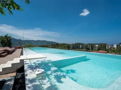 a large swimming pool with a view of a city at 2 спальни Апартаменты на Бангтао 600 метров от моря in Bang Tao Beach