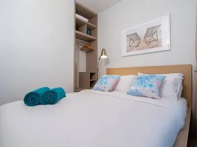 a bedroom with a large white bed with blue pillows at 2 спальни Апартаменты на Бангтао 600 метров от моря in Bang Tao Beach