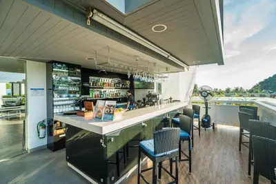 a restaurant with a bar with chairs and a view at Studio with pool access - Twin Sands by Lofty in Patong Beach