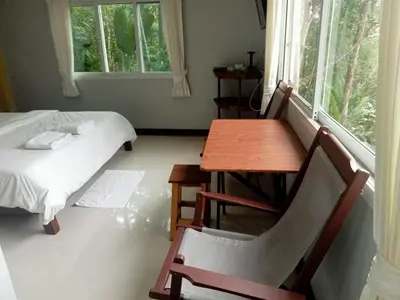 a room with a table and a bed and a table and chair at Mountain View Resort and Phupha Srirung Resort in Phuket Town