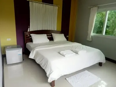 two beds in a bedroom with two towels on them at Mountain View Resort and Phupha Srirung Resort in Phuket Town