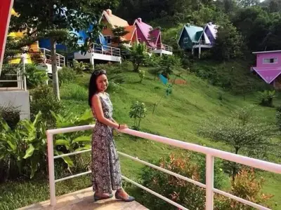 a woman in a dress standing next to a rail at Mountain View Resort and Phupha Srirung Resort in Phuket Town