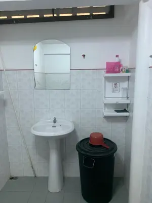 a bathroom with a sink and a trash can at Baan Ja Da in Ban Nai Khlong