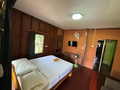 a bedroom with a white bed and a window at Baan Ja Da in Ban Nai Khlong