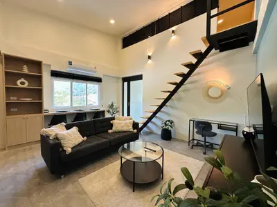 a living room with a couch and a staircase at Gloria’s Home in Kamala Beach