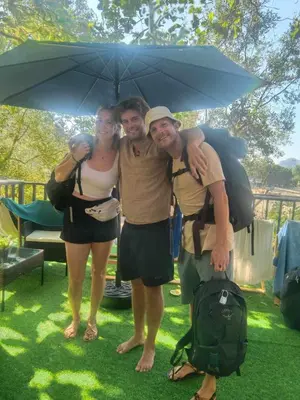 a group of three people standing under an umbrella at Sweed Dee Seaview Hostel in Phi Phi Don