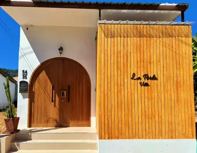 a wooden door on the side of a house at 2BR Pool Villa&Garden - Bali style by La Perla Phuket Rawai in Ban Saiyuan (1)